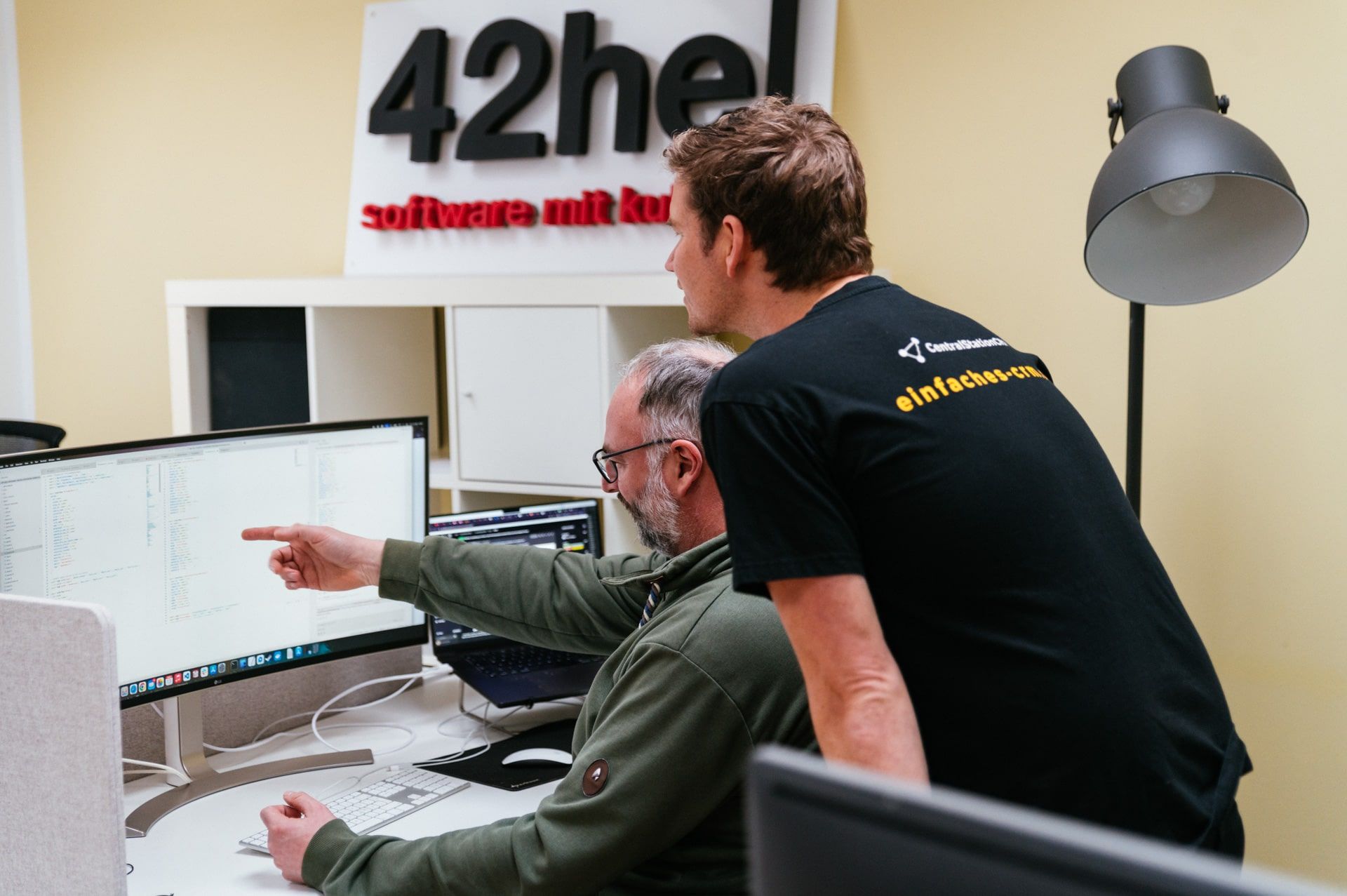 Arne und Axel checken Daten und Fakten vor dem Bildschirm.