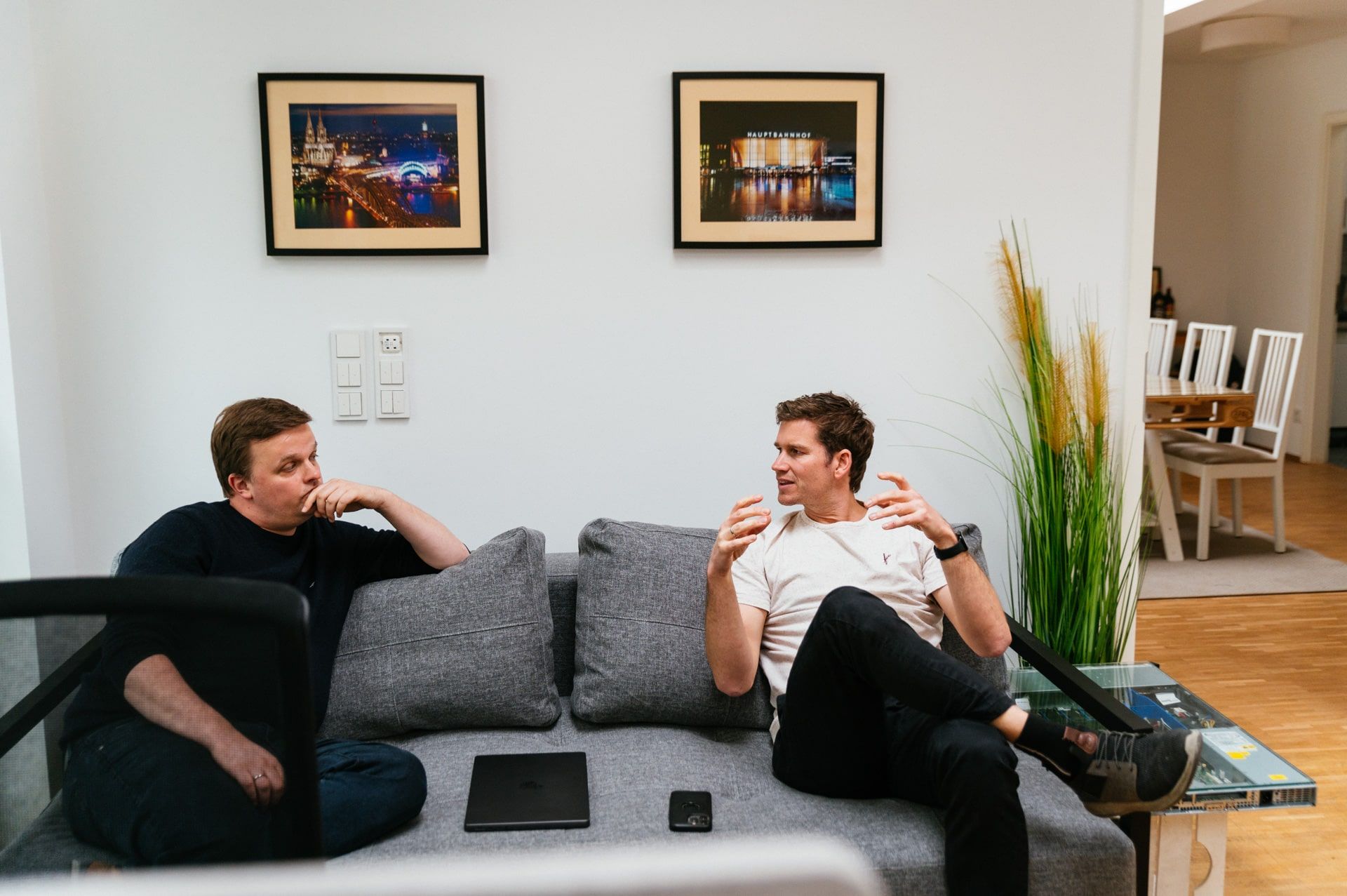 Christian und Axel sitzen auf der Couch und diskutieren.